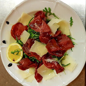 Bresaola-Carpaccio mit Rucola und Käseflocken